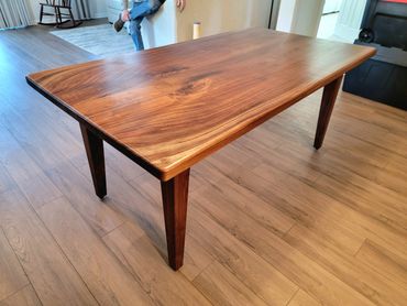 Polished wooden dining table with natural grain patterns in a modern room.