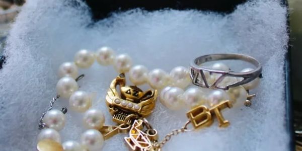 Pearl necklace with gold and silver rings.