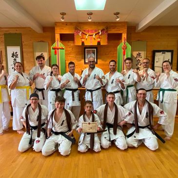 Groupe de karatékas posant après une cérémonie avec un certificat.