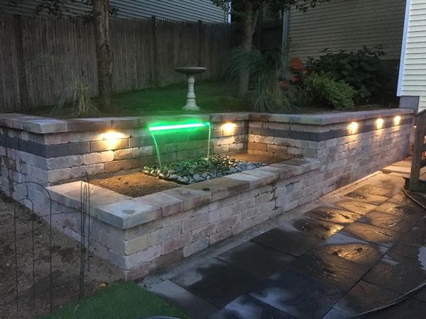 Elegant Retaining Wall with Waterfall Design and Uplighting