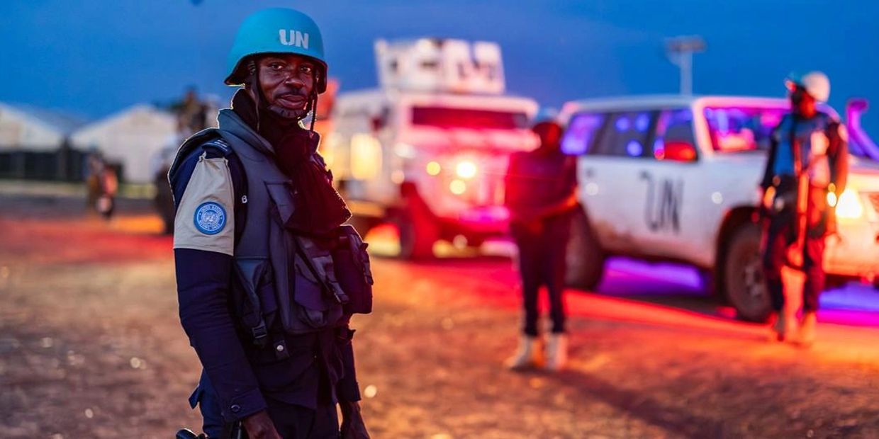 UN peacekeeper standing guard at dusk.