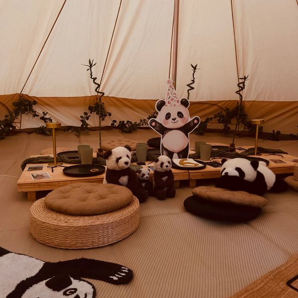 Indoor party setup with panda toys and cozy seating.