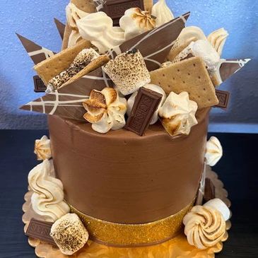 Chocolate cake topped with s'mores ingredients.