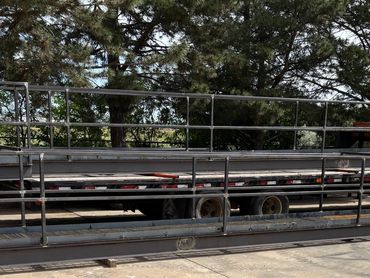 Long metal ramps with railings placed on a concrete surface near trees.