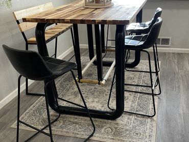 Modern dining area with wooden table, black chairs, and wall decor.