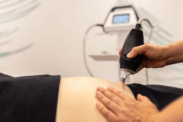 Close-up of a skin treatment device used on a person's abdomen.
