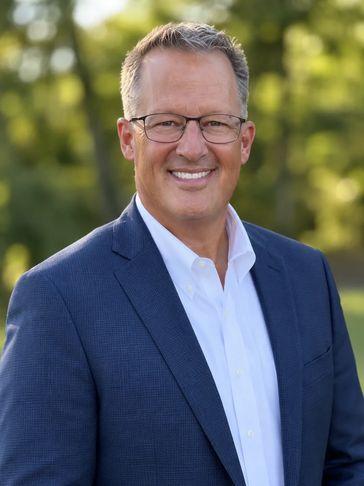 Smiling man in glasses and suit outdoors.