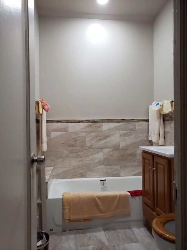 bathroom bathtub with clothes hanging on it