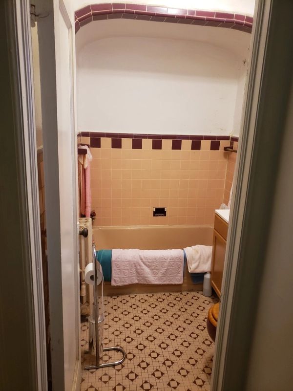 bathroom gate with towels hanging inside on the bathtub