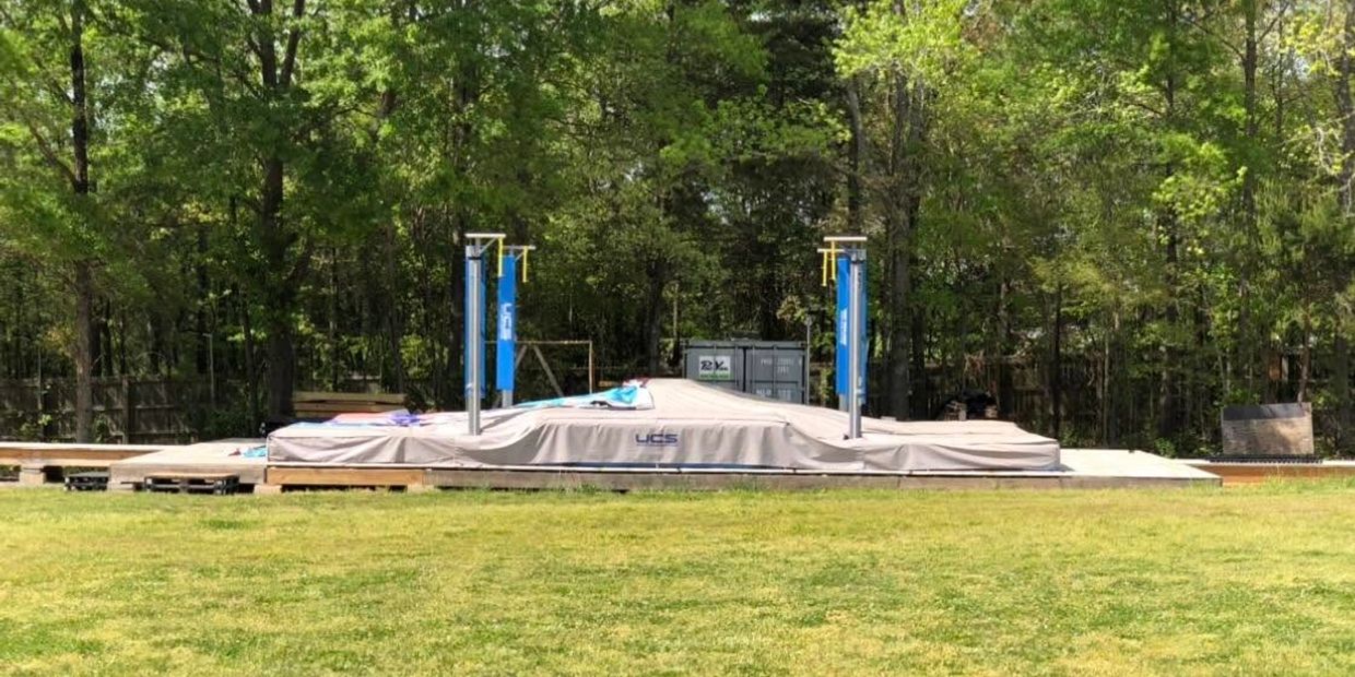 Covered high jump or pole vault mat in an outdoor field.