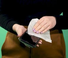 Correct method to clean cell phones.  Spray paper towel and wipe clean.