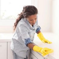 Cleaning countertops with a sponge and ZymeAway mixture.