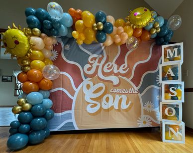Backdrop with Balloon Swag and Customized Baby Boxes to say the baby name.