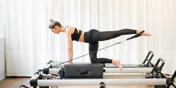 Donna che fa esercizi su un macchinario Pilates.