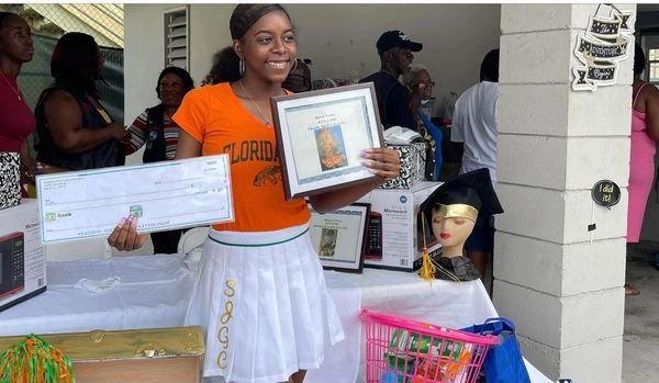 A woman holding up a check