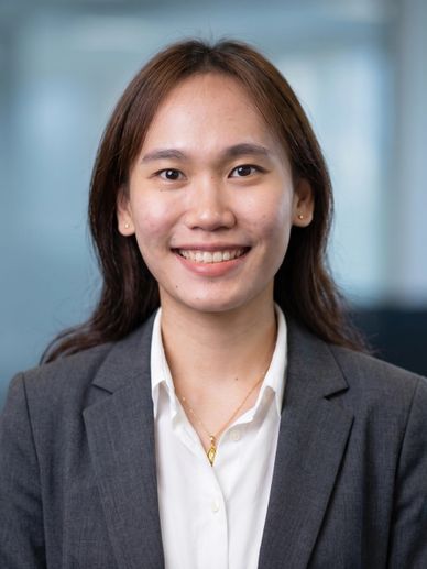 Smiling young woman in business attire poses for a professional headshot.