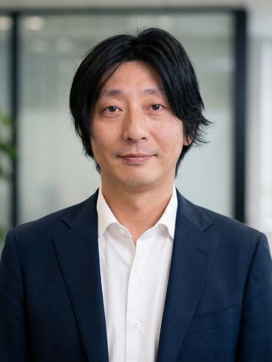 Portrait of a man in a navy blazer and white shirt.