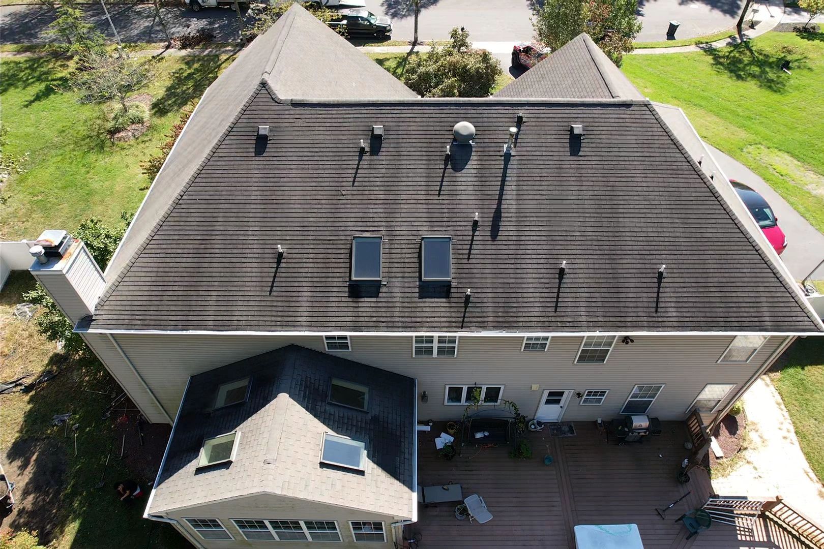 Aerial view of a large house with a rooftop and backyard.