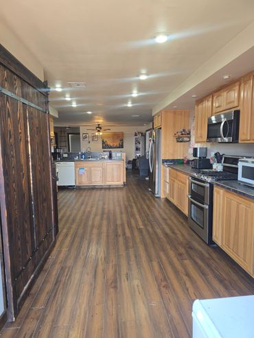 Spacious kitchen with wooden floors and cabinets.