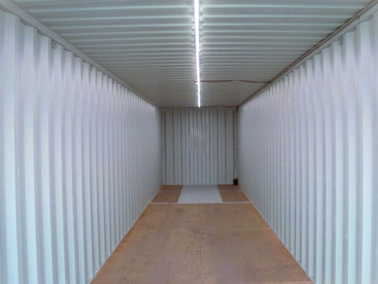Empty white shipping container interior with wooden floor.