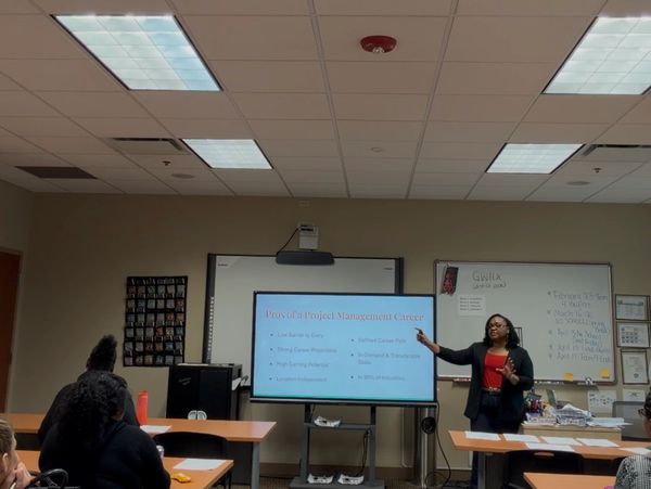 Woman giving a presentation on project management careers in a classroom.