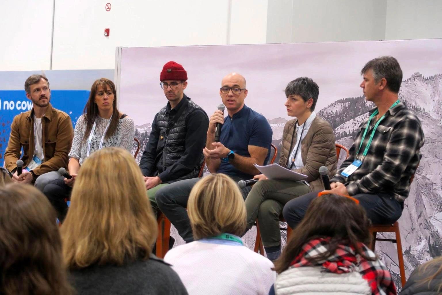 Panel discussion with six speakers addressing an audience.