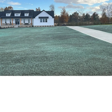 Modern white house with a large frosty lawn and clear sky.