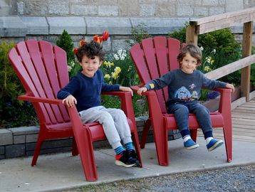 Two young boys enjoying their time at St. Alban's Centre, sitting on the Muskoka Chairs.
