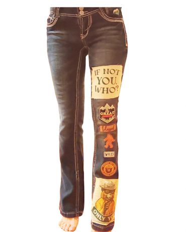 Dark jeans with colorful patches and inspirational text on one leg.
