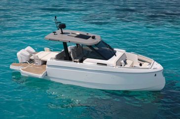 Modern white motorboat floating on clear blue water with dual outboard engines.