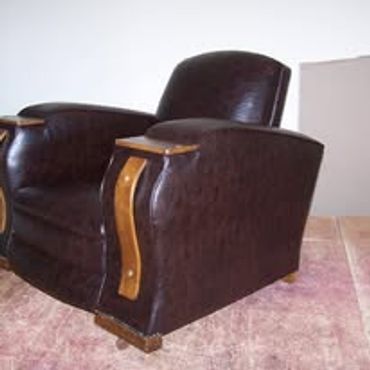 Vintage brown leather armchair with wooden armrest accents.