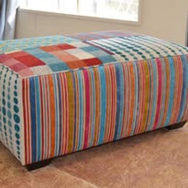 Colorful patchwork ottoman with stripes and dots pattern.