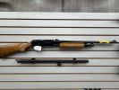 Disassembled shotgun with wooden stock on display