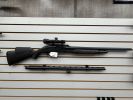 Bolt-action rifle with scope and a bipod on display.