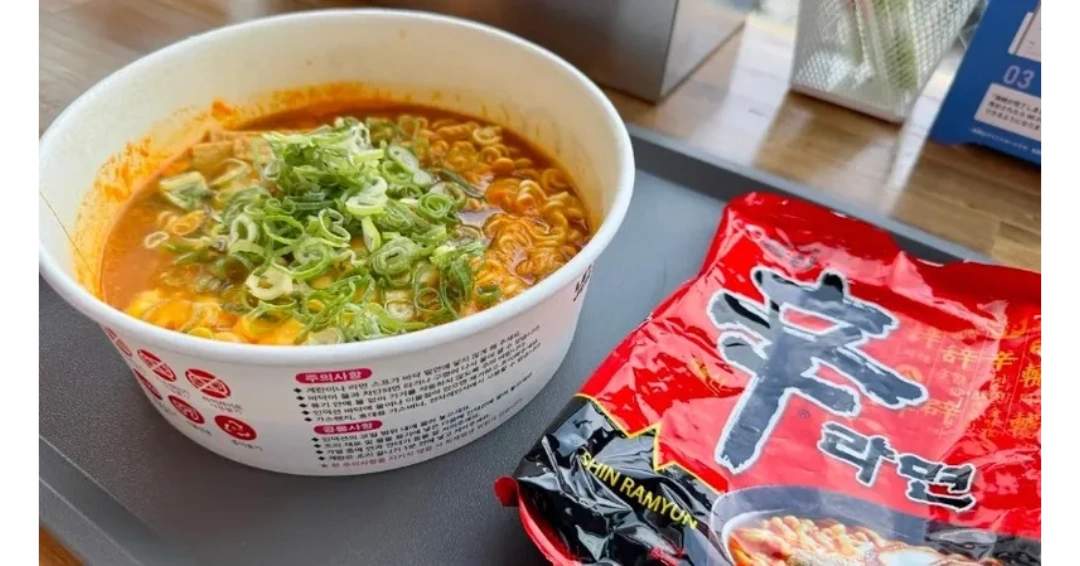 A bowl of spicy Shin Ramyun noodles topped with chopped green onions.