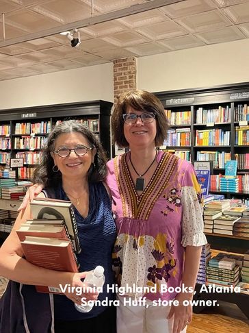 Two women posing inside a bookstore.