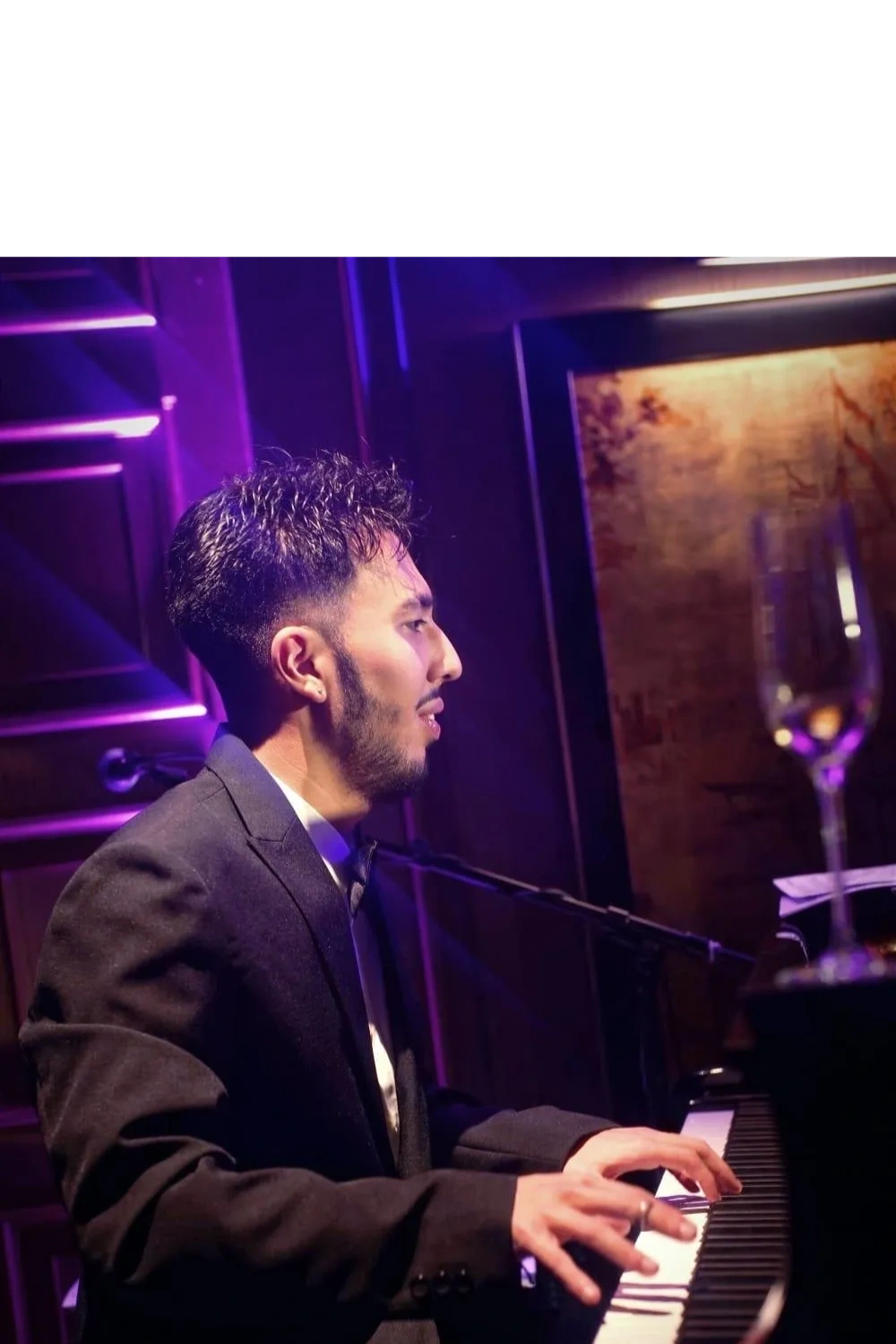 Man in a suit playing piano.