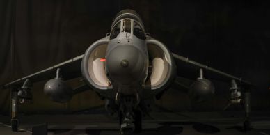 Front view of a military jet in dark surroundings.