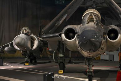 Two military aircrafts displayed in a hangar.