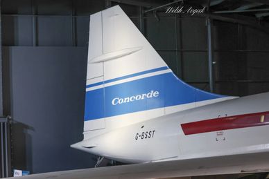 Tail section of a Concorde airplane inside a hangar.