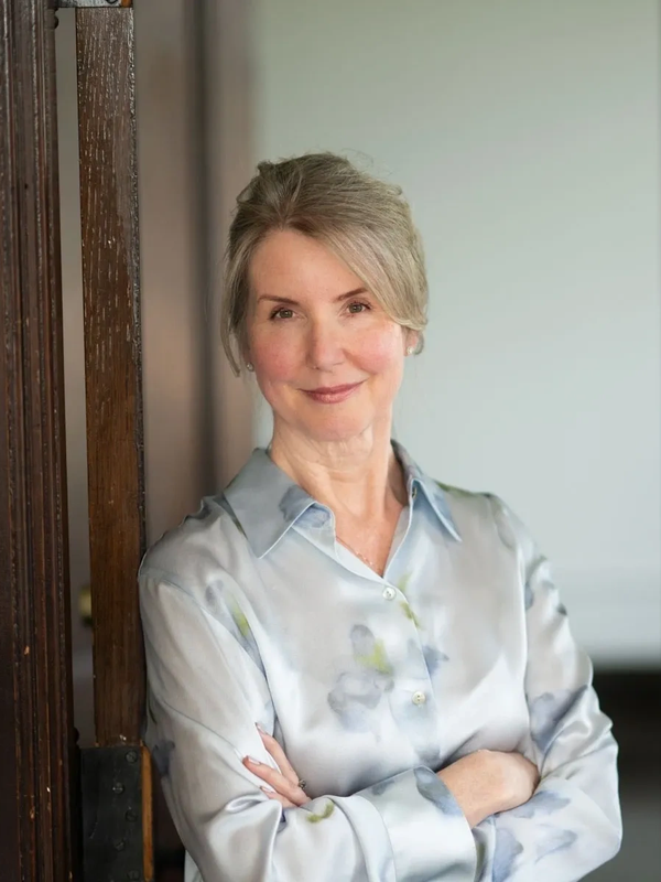 Confident older woman smiling with arms crossed.