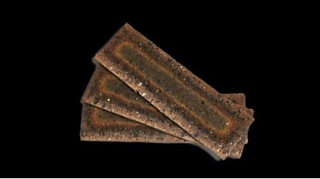 Three rectangular chocolate biscuits with one bitten, on a black background.