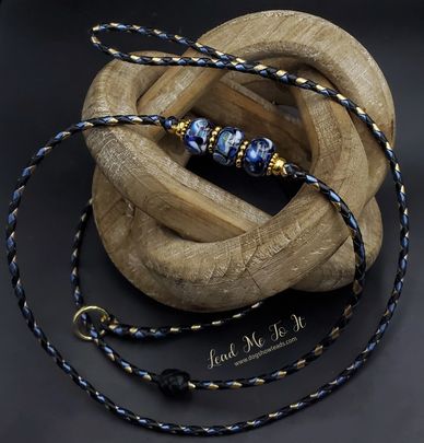 Elegant braided lanyard with decorative beads on a wooden knot sculpture.