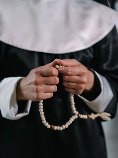 Close up of a nun's hands holding a rosary