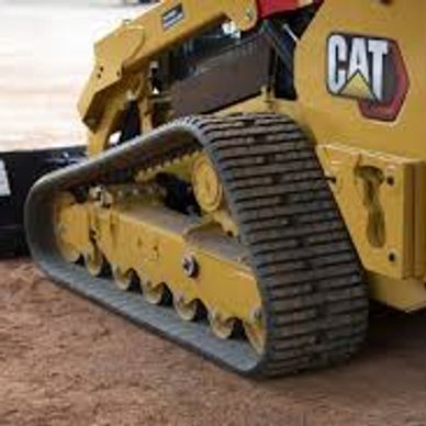 Close-up of a Caterpillar tracked vehicle on dirt.