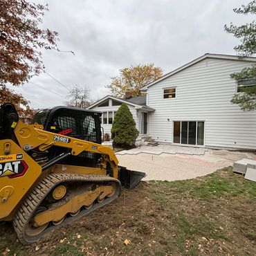 Construction of paver patio, skid steer machine, building