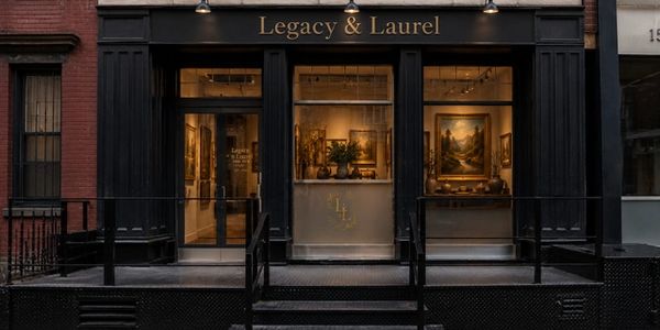 Art gallery storefront named Legacy & Laurel with framed paintings visible inside.