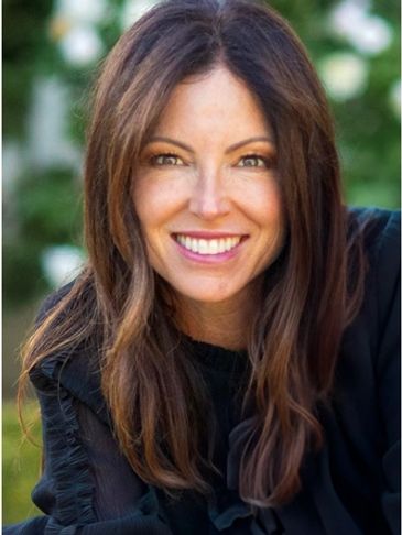 Smiling woman with long brown hair and a black top.
