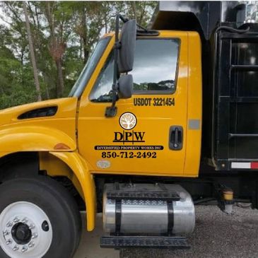 Yellow DLPW truck with contact number and USDOT details parked outdoors.
