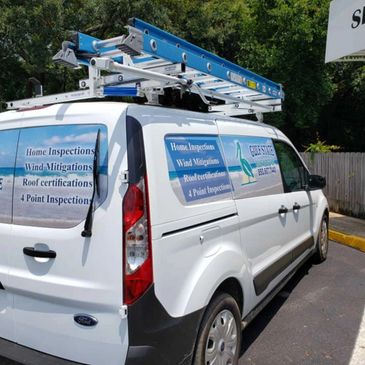 White service van with ladders and inspection service signage.
